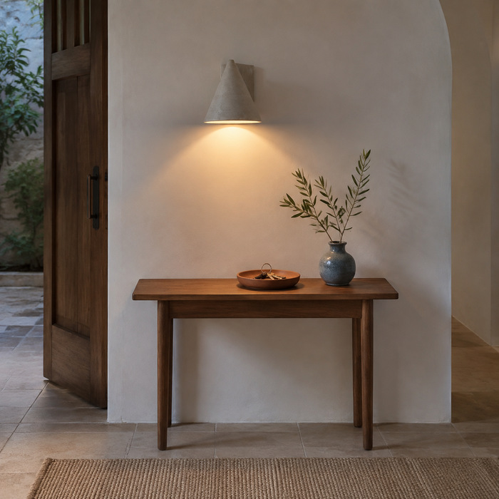 Entree van Airbnb met een warme betonnen wandlamp.
