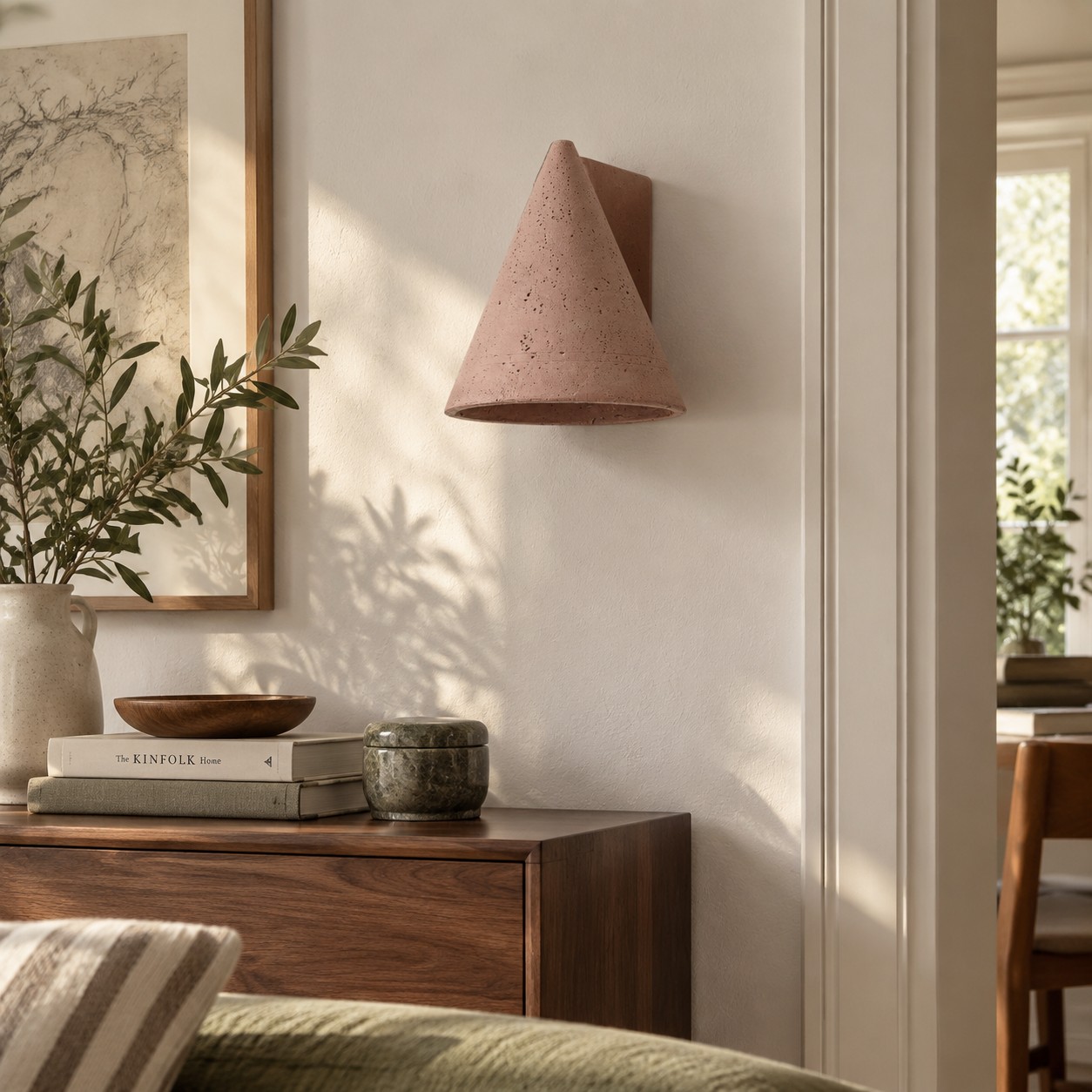 Baksteenrode betonnen wandlamp, afgestemd op meubels in walnoot- en olijfkleur.