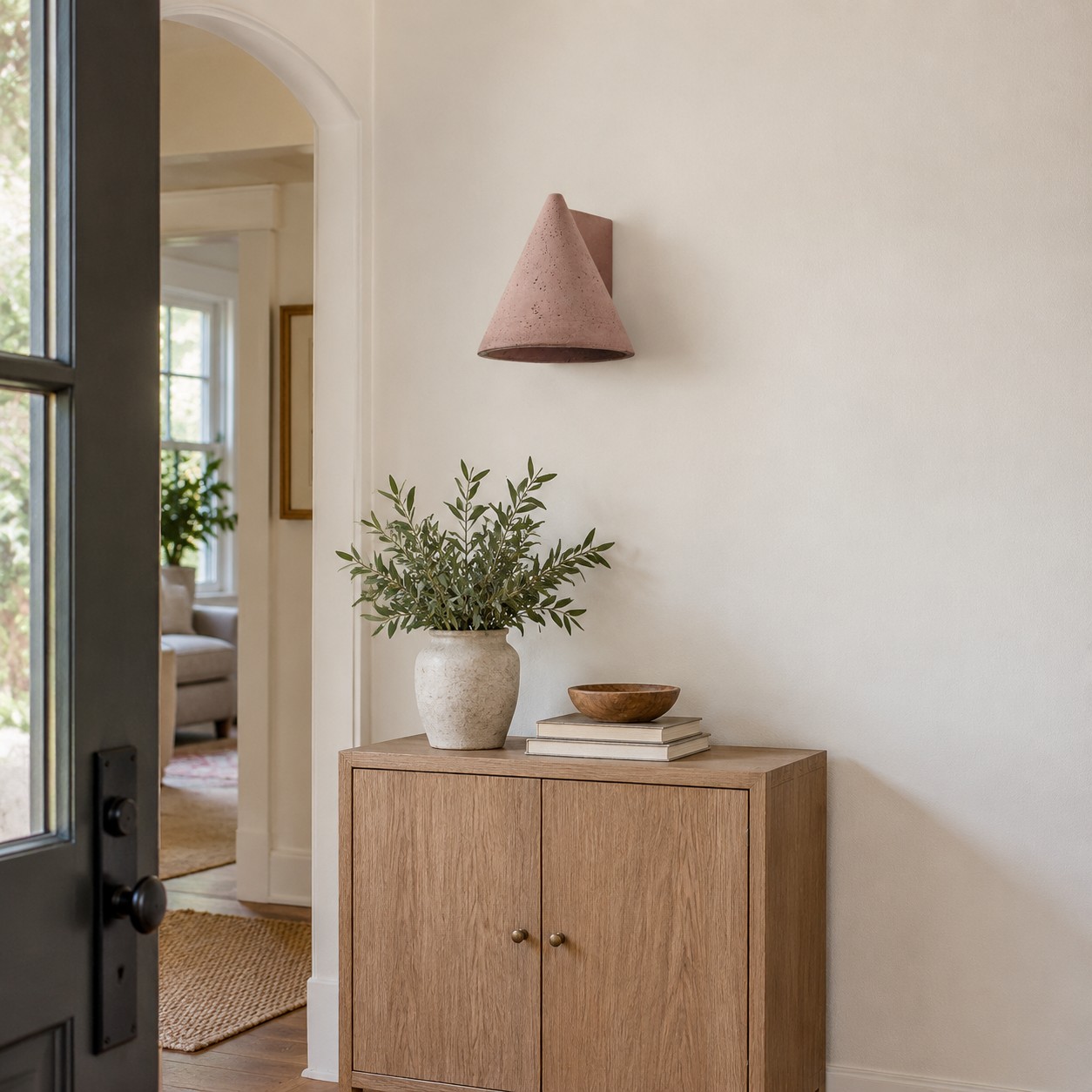 Een baksteenrode, sculpturale wandlamp is duidelijk zichtbaar vanuit de ingang van een kamer.