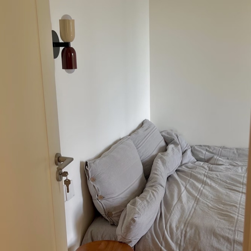 Aplique Symra junto a una cama en reseña de cliente