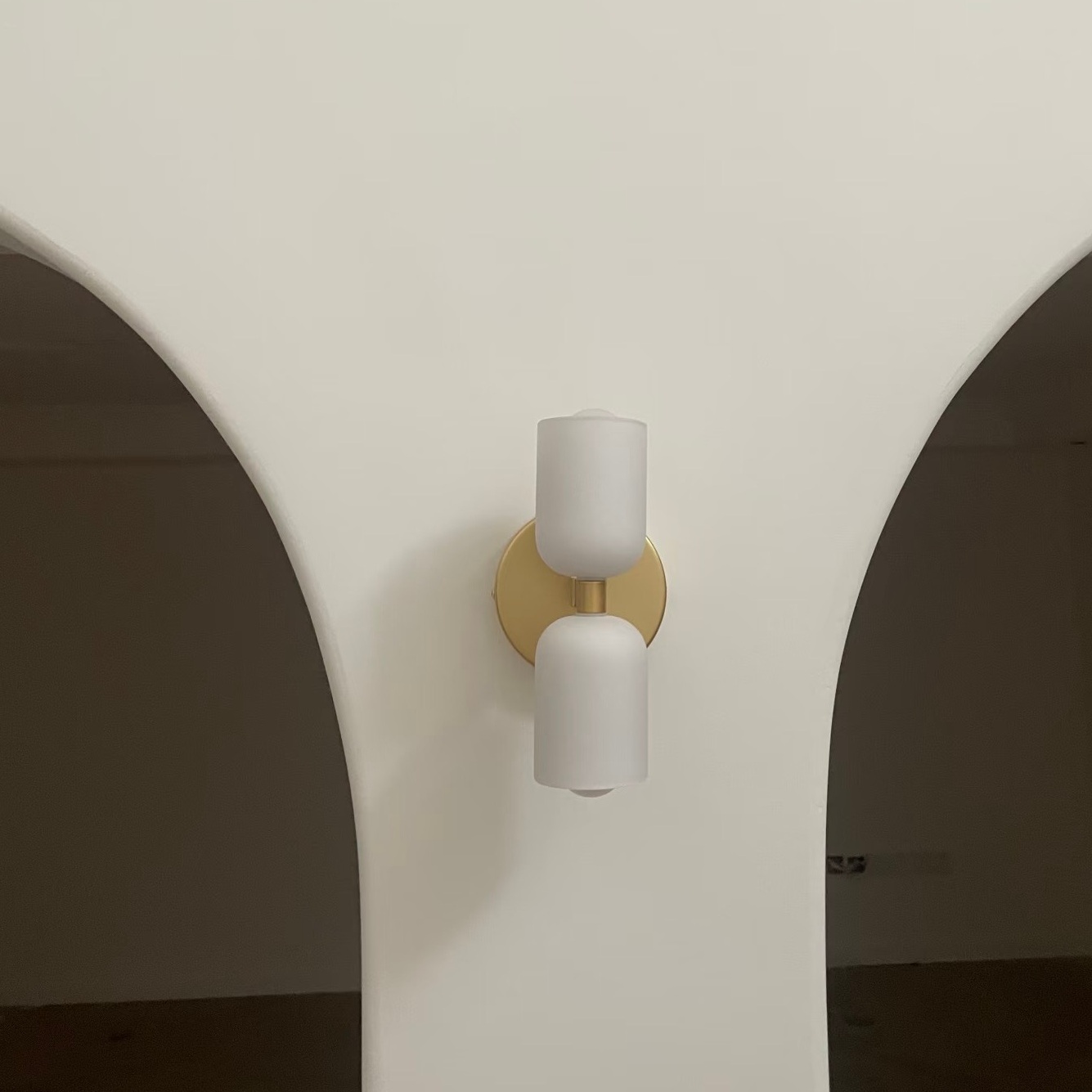 Aplique Symra en una pared con arco