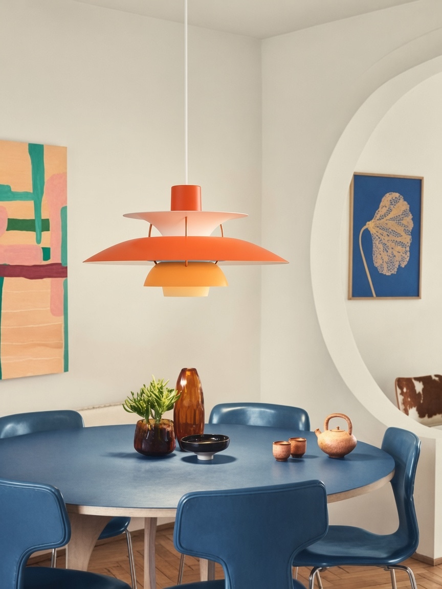Lámpara naranja por capas sobre una mesa de comedor azul