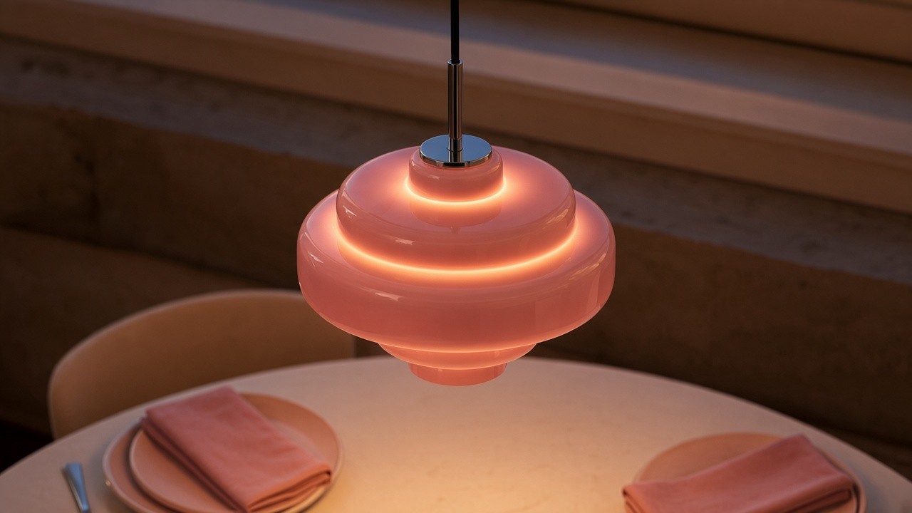 Lámpara rosa de tres niveles encendida sobre el comedor