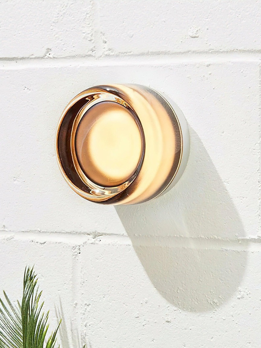 Aplique Shadow Ring ámbar en un muro texturado
