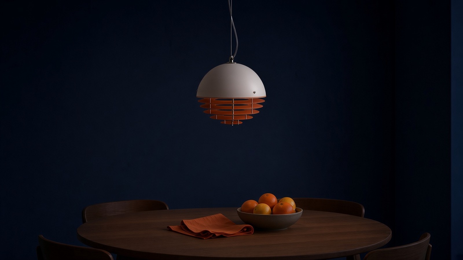 Lámpara de capas blanco y naranja apagada sobre el comedor