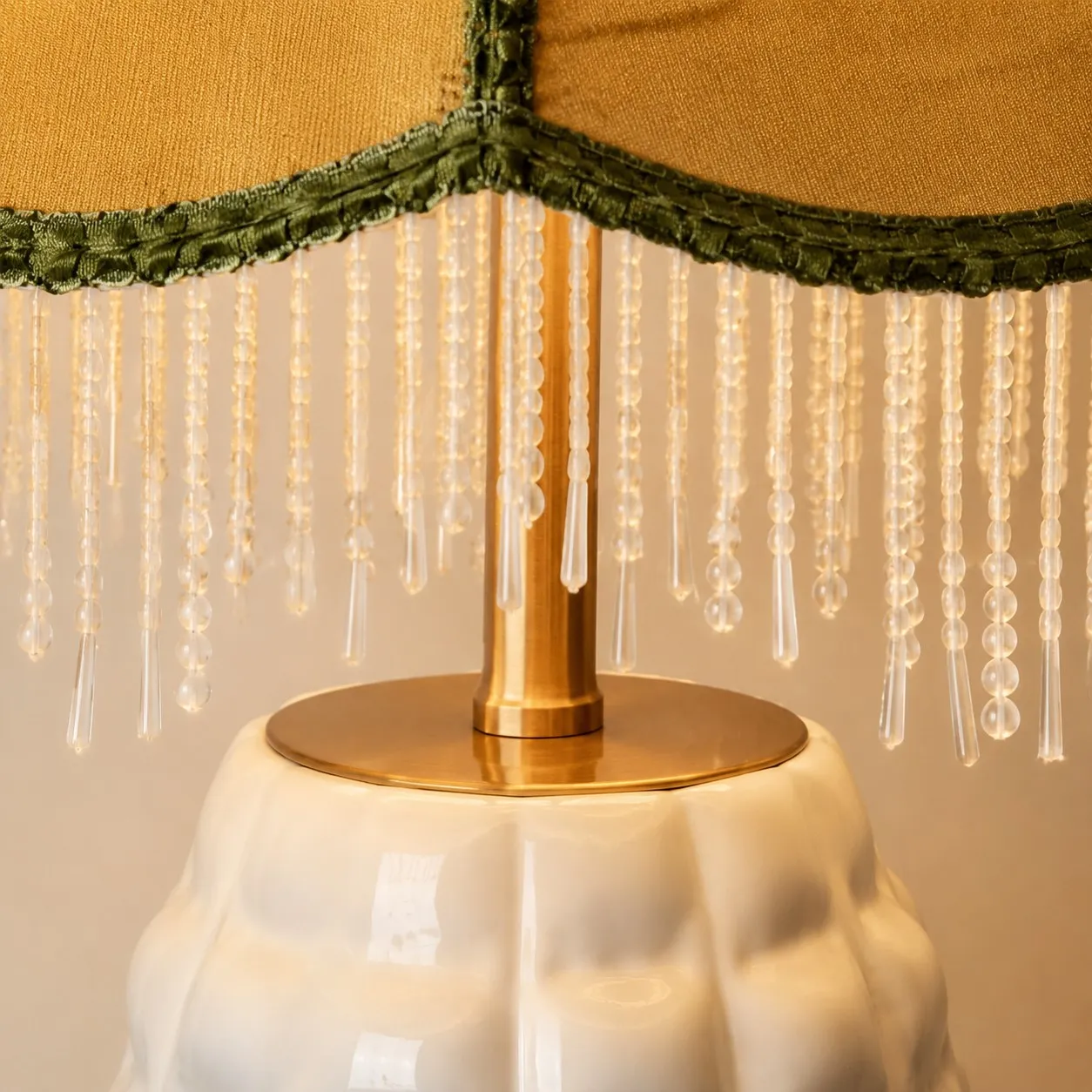 Close-up of beaded fringe and brass lamp fitting