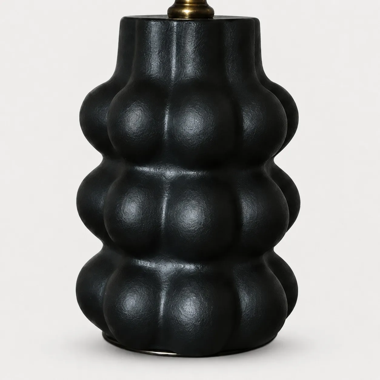 Sculpted matte black ceramic lamp base detail