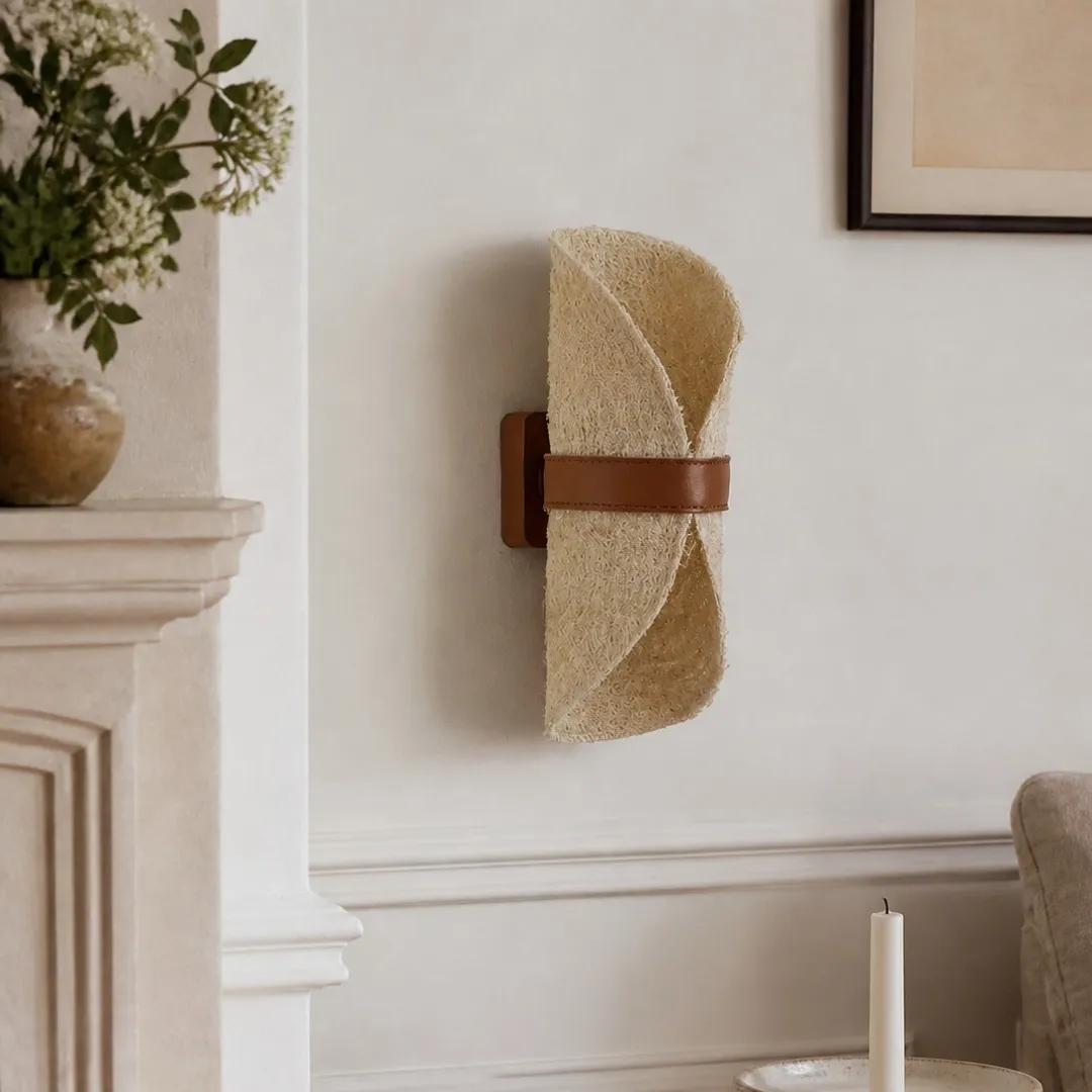 Natural loofah and leather wall sconce in a refined neutral interior