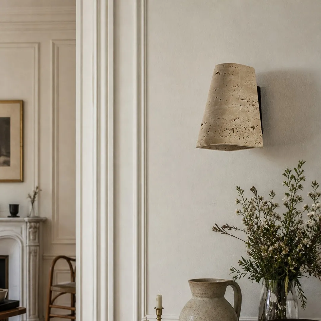 Travertine wall sconce installed in a refined dining interior